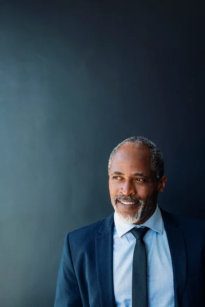 Everett Boone, founder and broker-in-charge, in a navy suit against a dark studio background