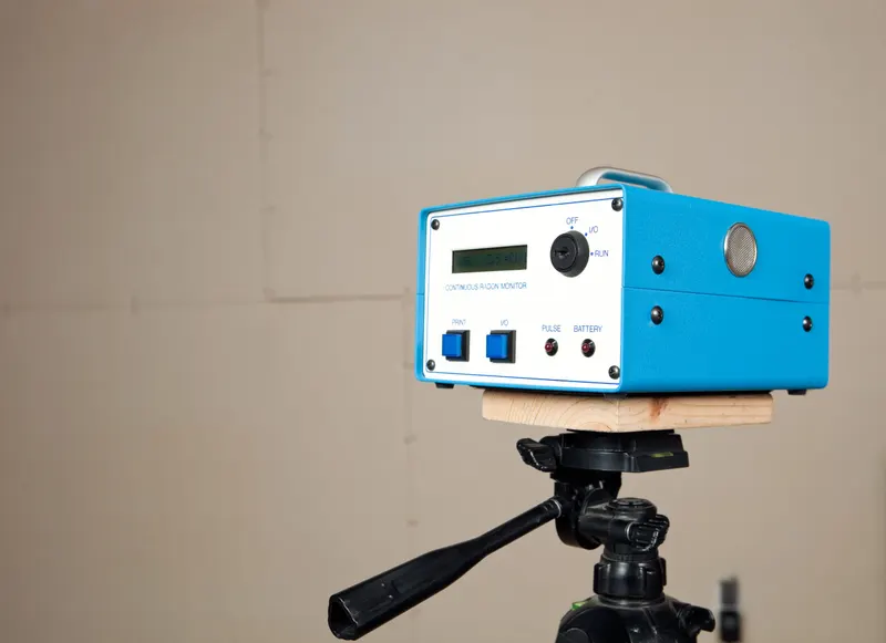 Continuous radon monitor mounted on a tripod in a basement during a 48-hour test