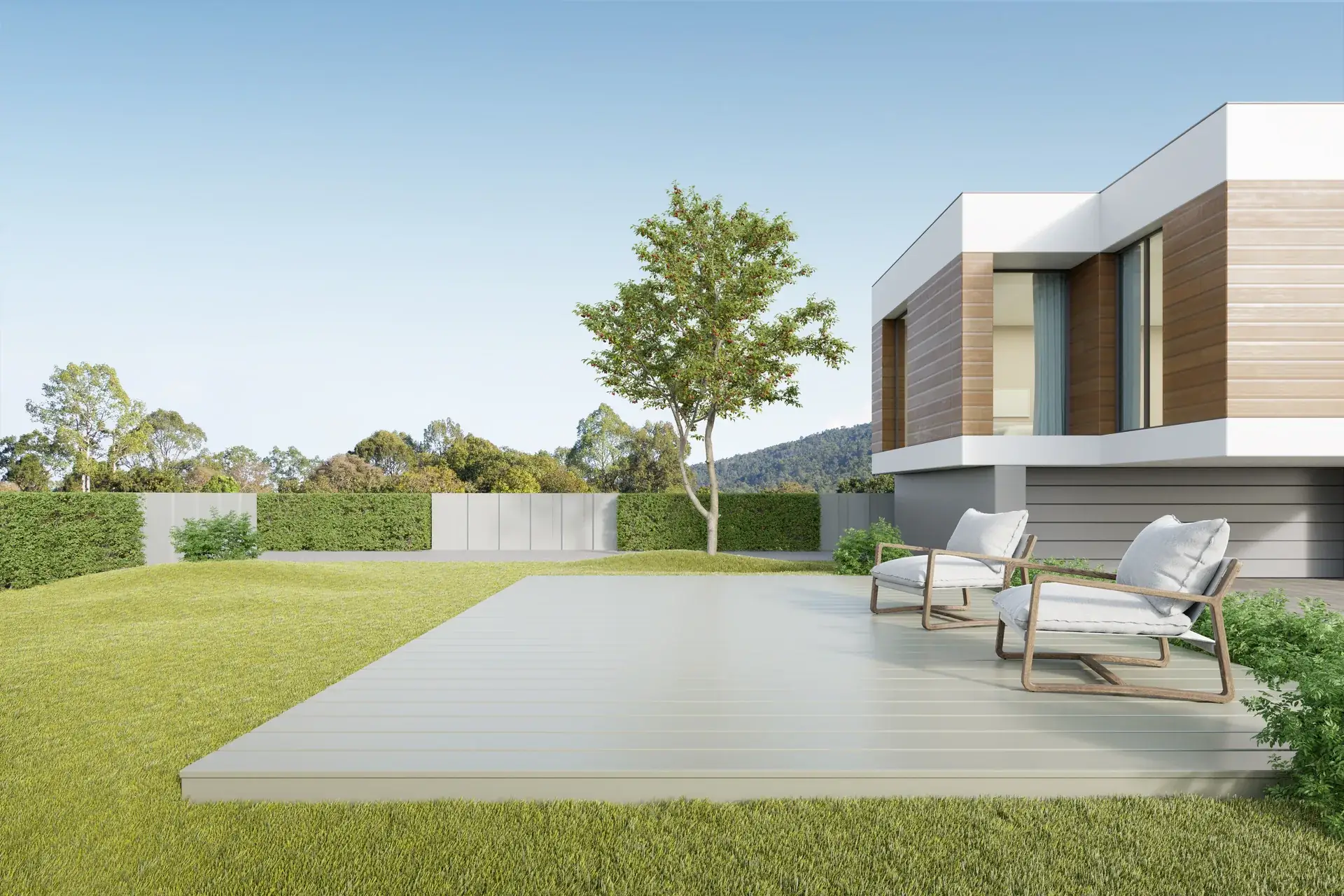 Vale House — a cantilevered timber-and-white volume behind a broad lawn, two lounge chairs on the pale deck under an open sky