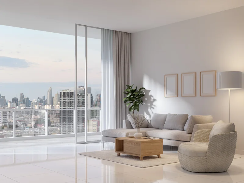 Residence 48's white-on-white living room, sheer curtains drawn back from a glass wall overlooking the Alderport skyline