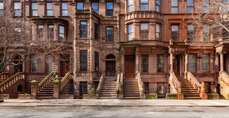 Row of ornate 19th-century brownstones on Rowan Terrace, carved stone stoops climbing to arched double doors