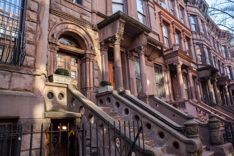 Carved sandstone columns and curved stoop balustrades along the Rowan Hill streetscape