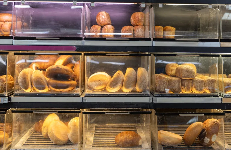 The Depot's bread wall — wooden shelves and bins stacked with the day's boules, batards, and pan loaves