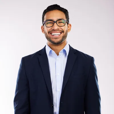 Portrait of Dev Raghavan, head of product at Copperline Labs, smiling in glasses and a navy blazer