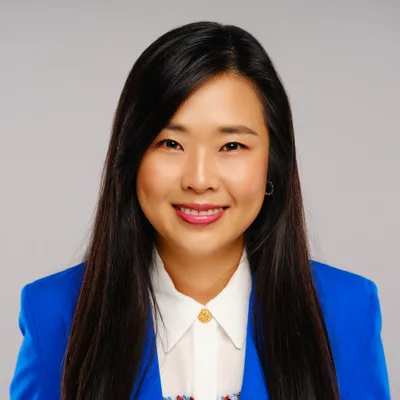 Portrait of Mei Nakamura, co-founder of the design studio Fathom & Frame, smiling in a bright blue blazer